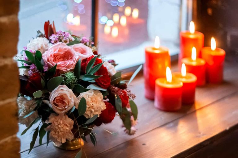 red green candles and bouquet of flowers on a wind
