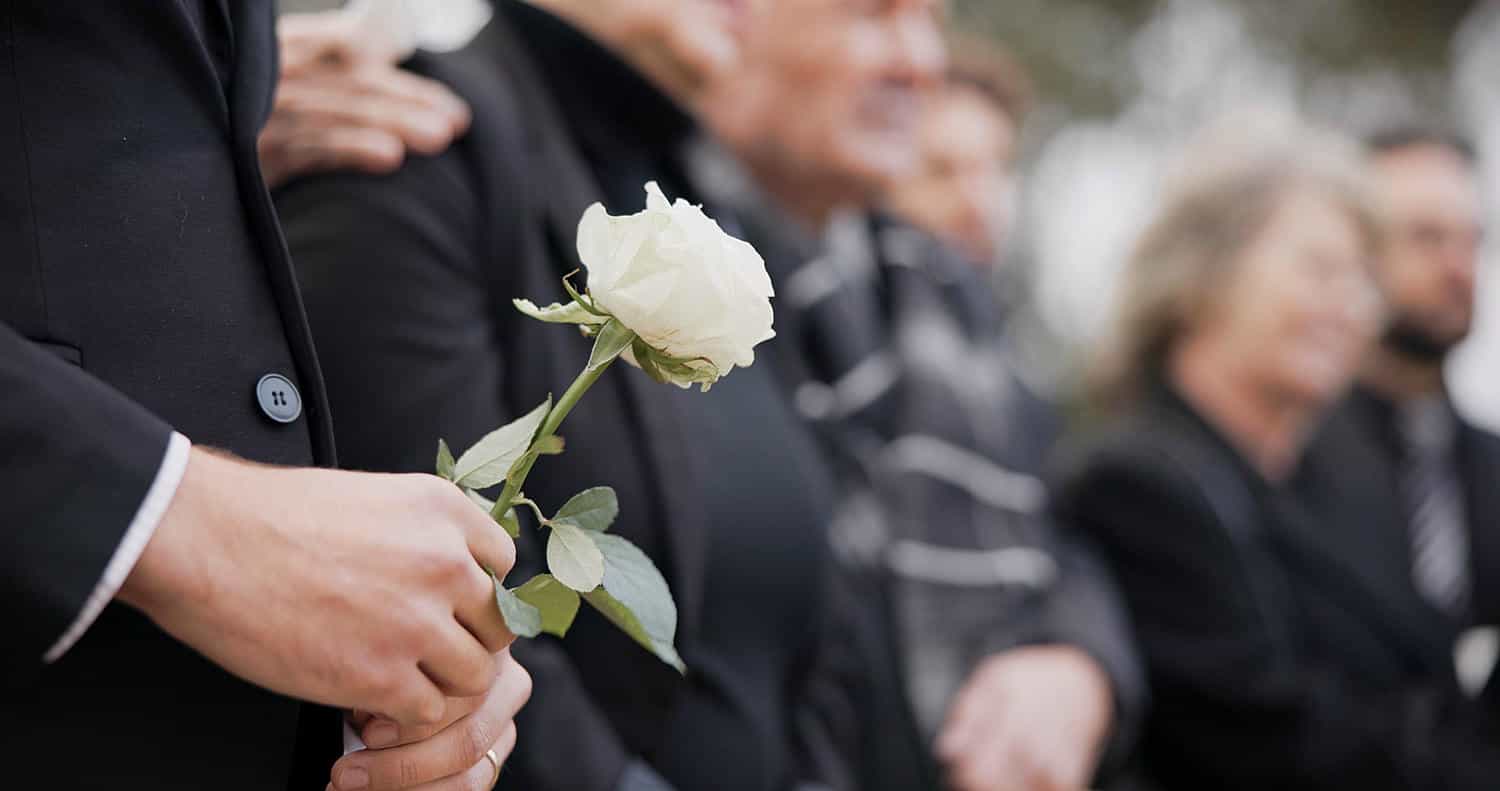 hands rose and a person at a funeral in a cemeter