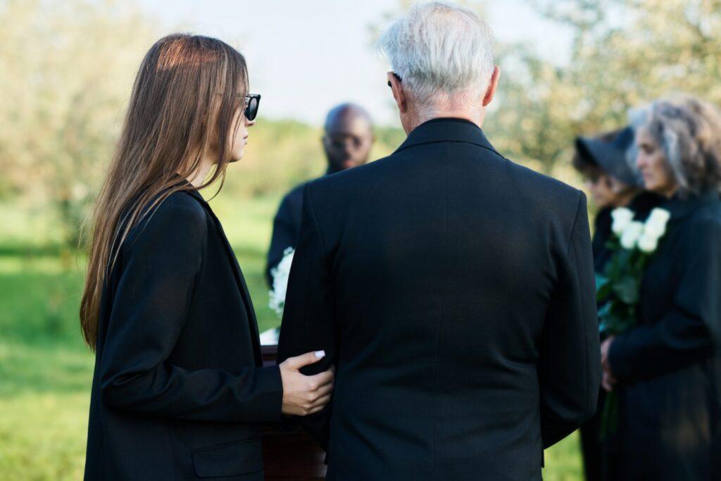 A woman comforting a grieving family member at a funeral service